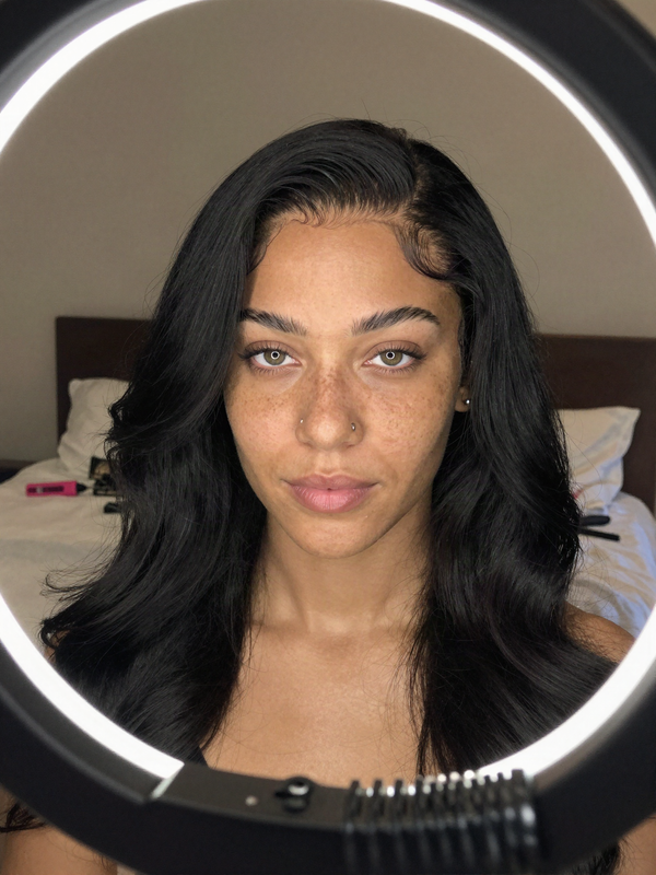 Smoothing the lace hairline of a freshly installed wig at a vanity